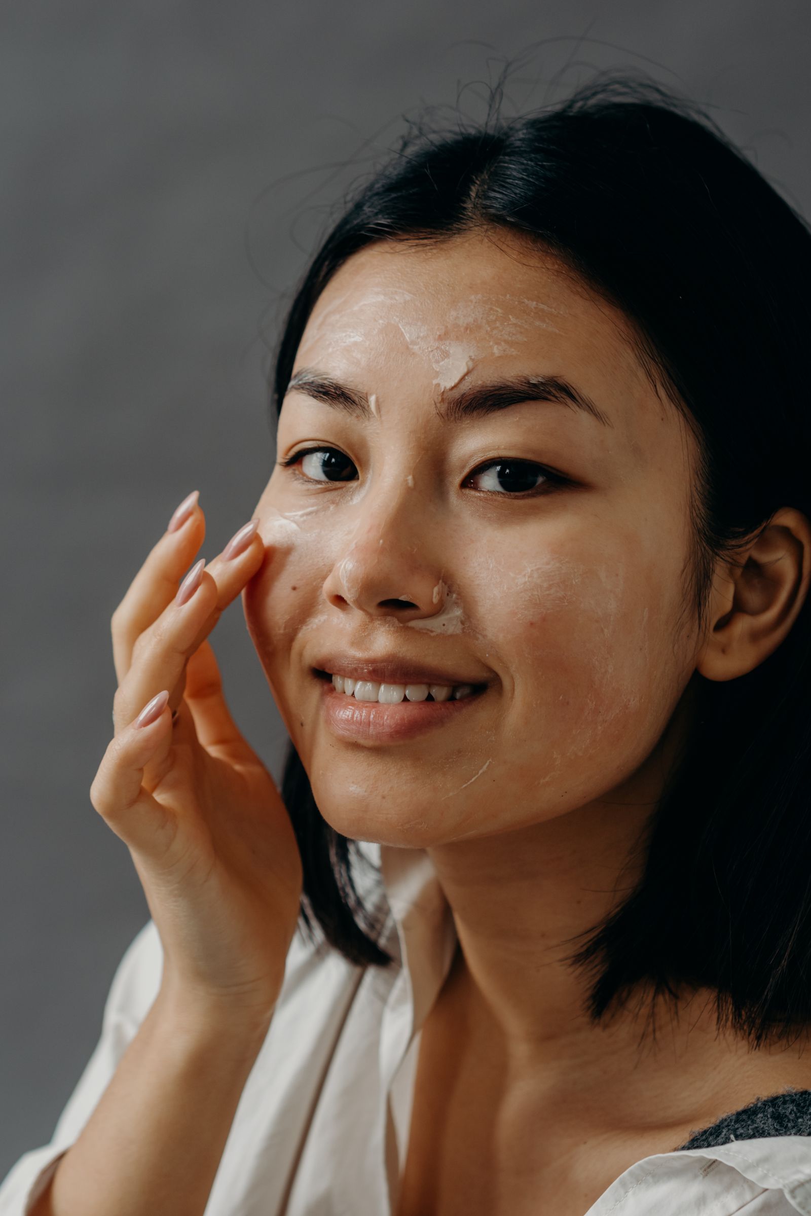 Mulher aplicando um produto de cuidado facial